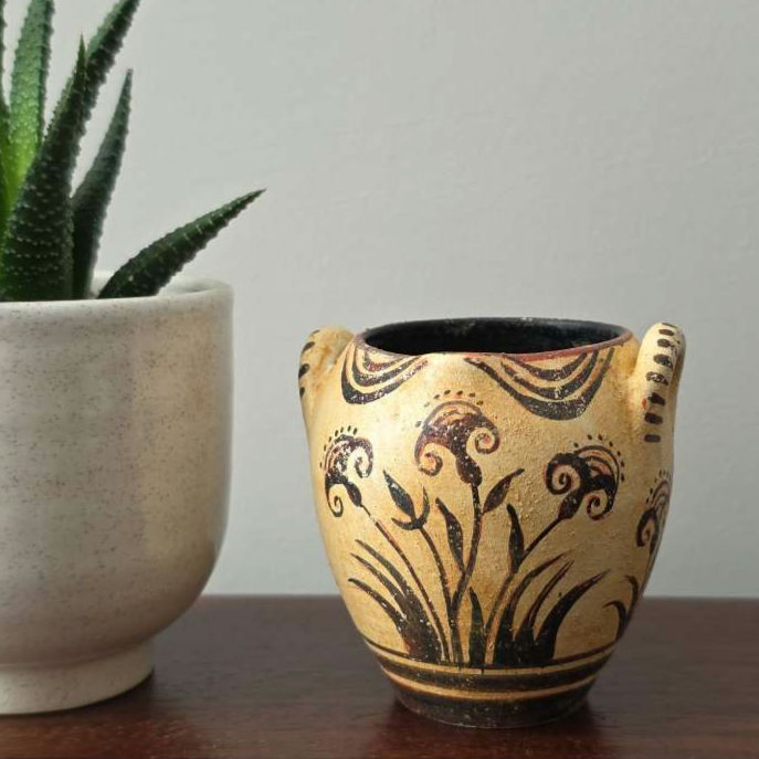 Minoan vase with smiling papyrus pattern near a succulent