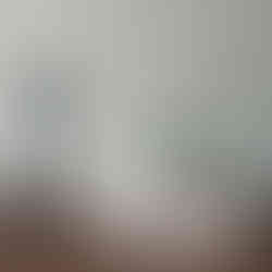 Bronze Apollo figurine with lyre next to books and plant.