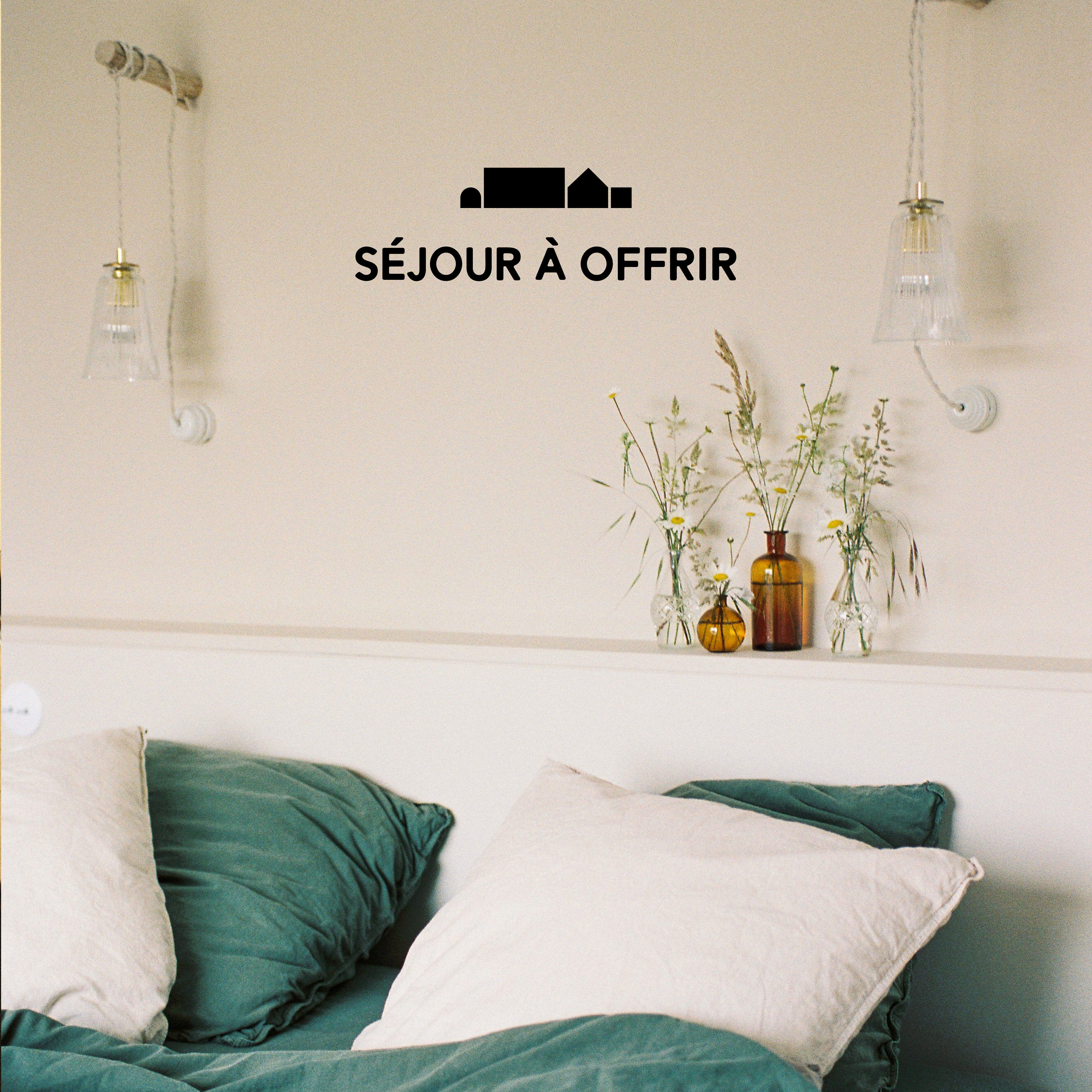 Séjour à offrir à Maison Le Détour, chambre avec linge de lit vert et fleurs sur la tête de lit