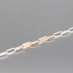 Armband aus langen, ovalen Ösen. Dazwichengestzte sind zewi ovale Platten aus Roségold, mit Gravur von Namen