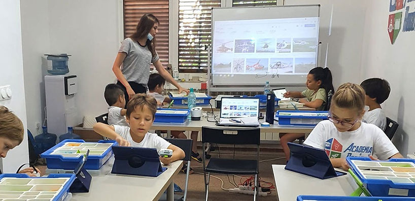 copii in sala de clasa construind roboti la tabara de vara robotica-marea-aventura la Academia de Robotica