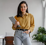 business woman cu ochelari si cu laptopul in mana, pozand la camera