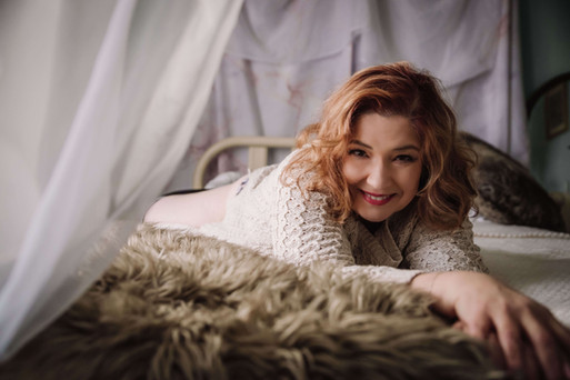 a woman smiling in a canopy bed in newberry sc