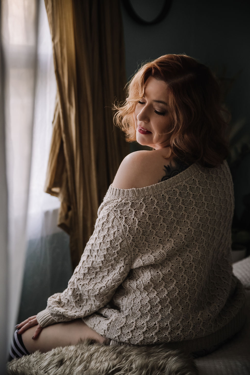 Confident woman photographed by Bare Elegance Boudoir in a soft luxury bedroom setting