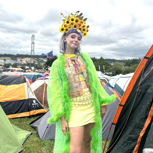 Girl wearing a green outfit and large sunflower headdress