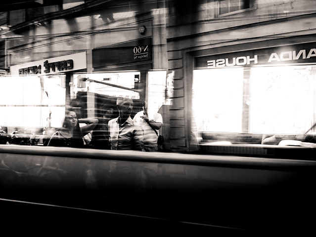 Des piétons en reflet dans un bus