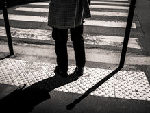 Un homme attend que le feu passe au vert pour traverser.