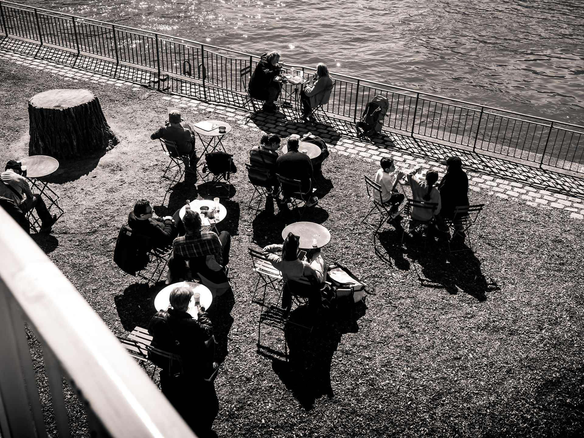 Des gens attablés au bord de la seine