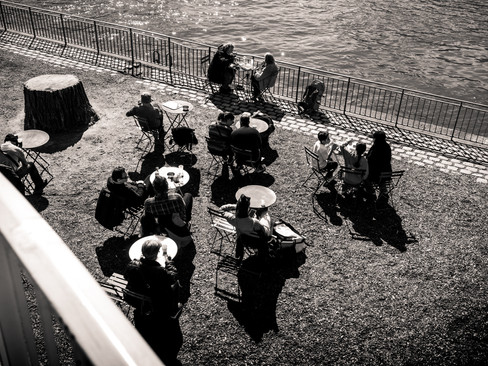 Des gens attablés au bord de la seine