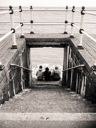 Des amis assis sur des marches au bord de l'eau