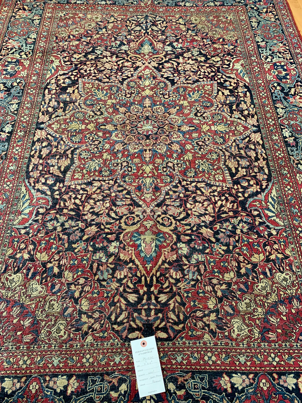 Thumbnail: Antique Lavar Kerman rug with a classic floral medallion design.The rug showcases a rich color palette of reds, blues, green.