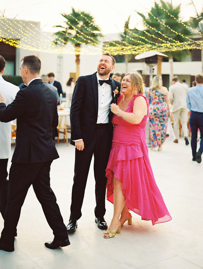 Wedding guests laughing together during a wedding in Los Cabos.
