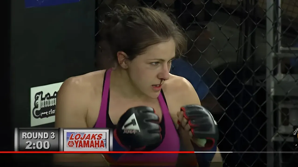 Jess Sargus mid-fight ready to enter Round 3 with a bloody nose.