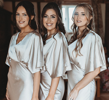Three bridesmaids smiling and posing for the camera