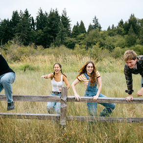 Adolescentes saltando una barrera de madera sobre un prado