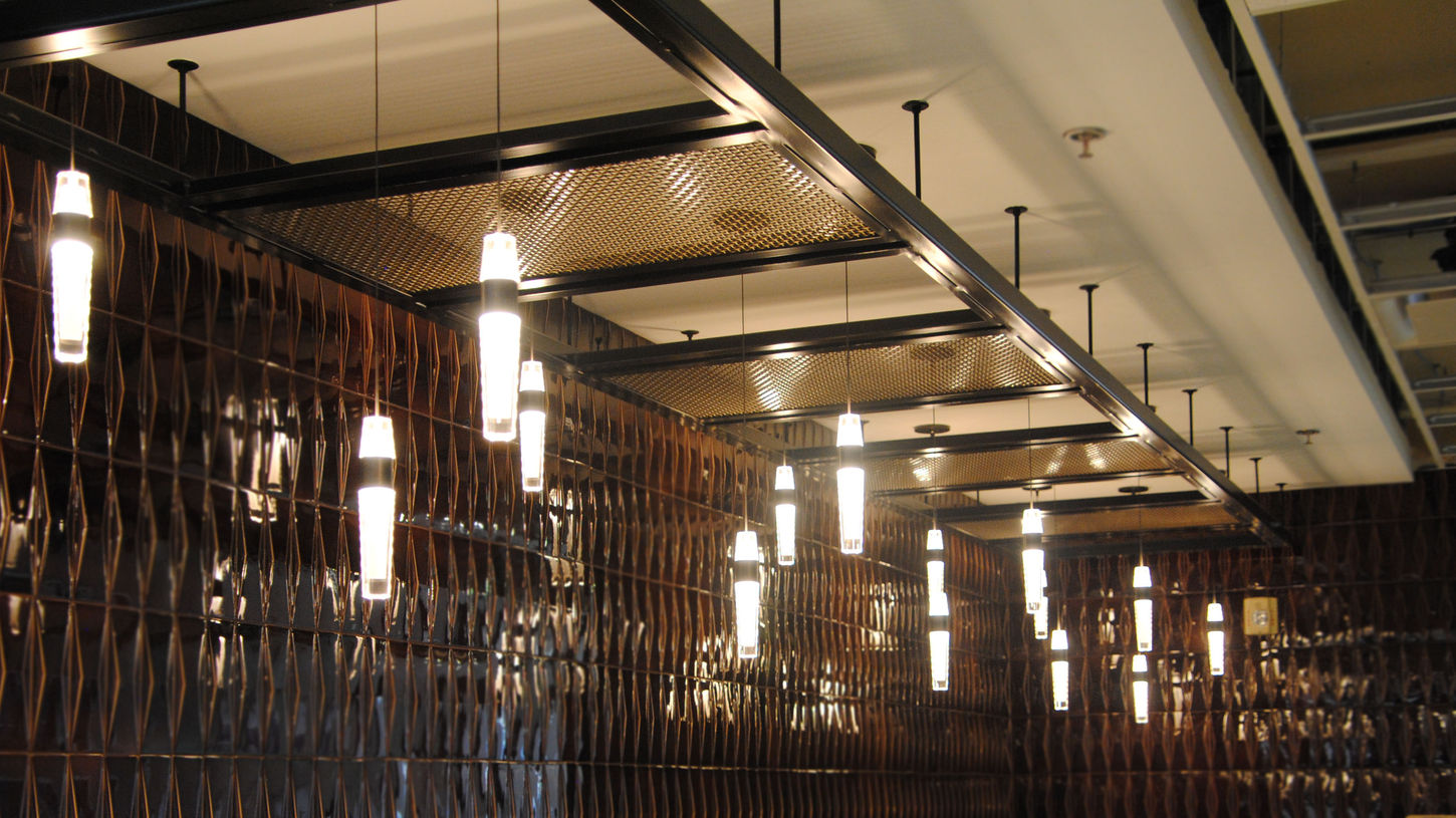 Decorative pendant lighting installed along a tiled commercial interior