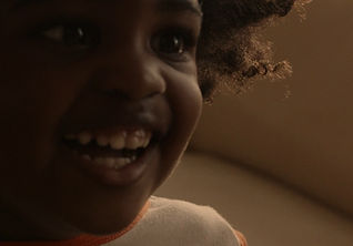 A close up of a Black child laughing. 