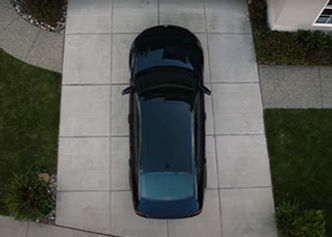 Overhead shot of a blue SUV exiting a driveway.