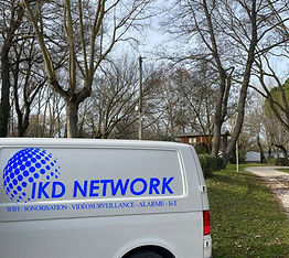 Camionnette IKD Network garée sur un chantier dans un camping