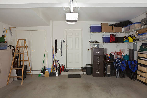 Cluttered garage with tools, bikes, and storage items.