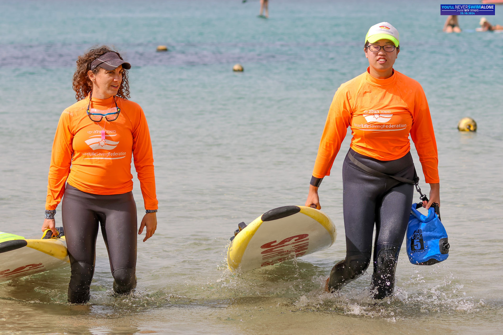 Safety team members coming ashore with their boards on Gordon Beach.