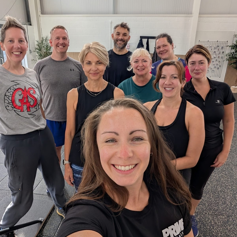 Group of male and female members smiling after a training session at Prime Fitness