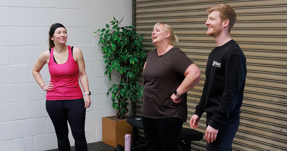 Smiling group of members of Prime Fitness gym in Royal Wootton Bassett who are feeling stronger, fitter and more confident in what their bodies can do, in a gym near them.