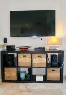 TV stand with natural decor and storage baskets.