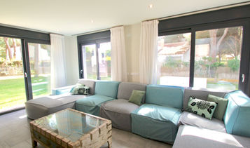 Comfortable sofa facing floor-to-ceiling glass doors.