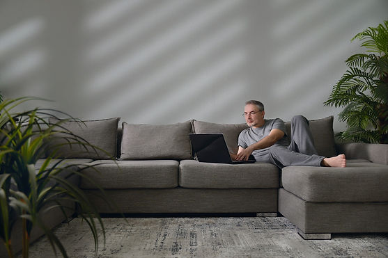 man-with-a-laptop-on-a-couch-2023-11-27-05-36-48-utc.jpg