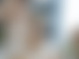 A small business owner prepares customer orders, using a smartphone beside a laptop with packaged products ready for shipping.