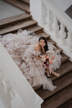Model auf Treppe mit Tuellkleid und Blumen