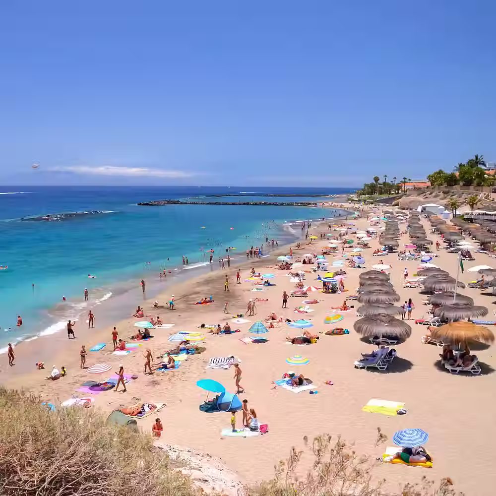 Playa del Duque is an exclusive, upscale beach in Costa Adeje, Tenerife, renowned for its golden sand, crystal-clear turquoise waters, and luxurious atmosphere. Awarded the Blue Flag status, it offers excellent facilities such as lifeguards, sun loungers, and exclusive shops and restaurants nearby. The area is surrounded by five-star hotels and a picturesque promenade.