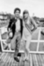 Black and white photo of man and woman on balcony with guitars