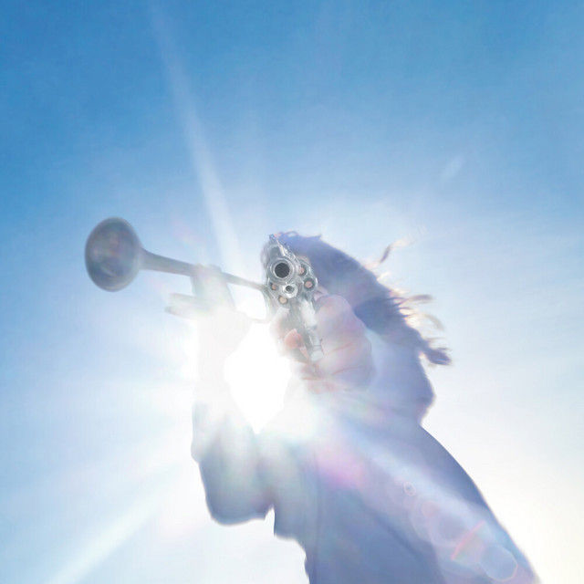 Angel against blue sky with horn and revolver
