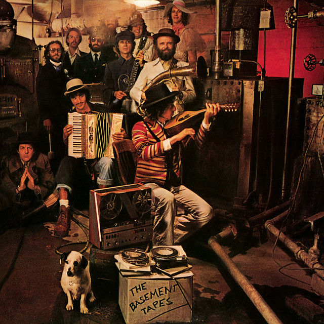 Bob Dylan and The Band posed in basement with musical instruments and costumed characters