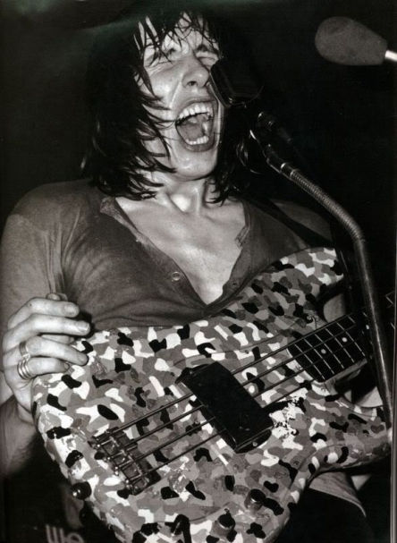 Sweaty long haired man screams into microphone