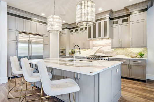 bright transitional kitchen marble counters and chandeliers