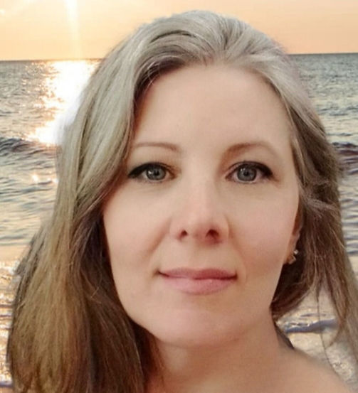 meu rosto, pele clara, olhos azuis, cabelos loiros e atrás o oceano