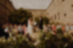 Bride speaking out her vows to the groom during a wedding ceremony, while guests are watching