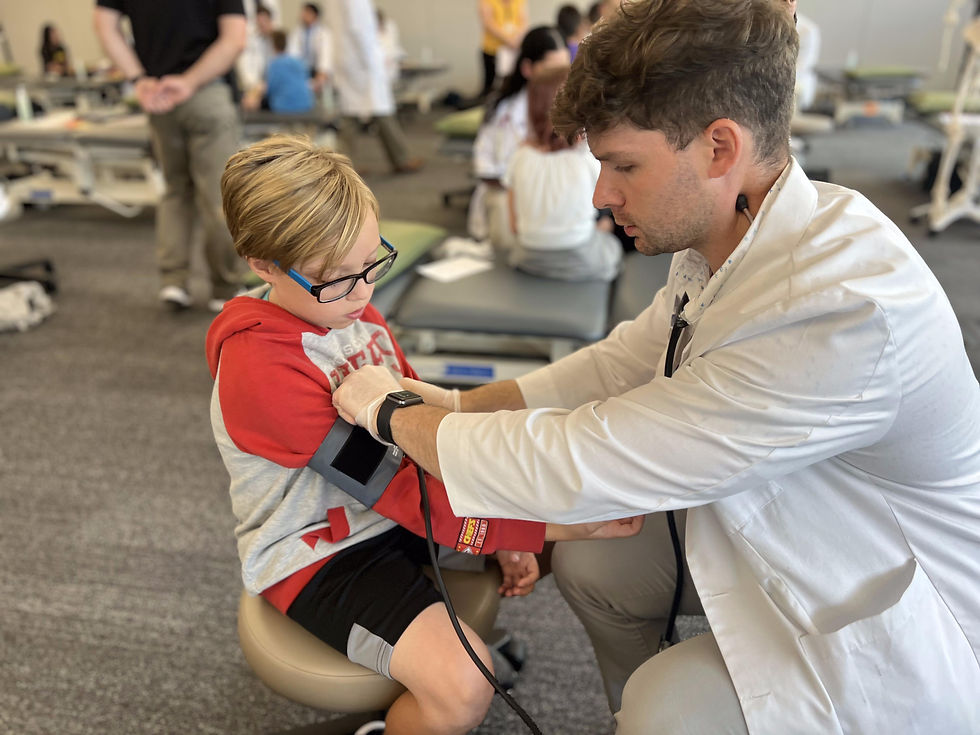 Male physician placing a blood pressure cuff on a child for Score 1 for Health screenings