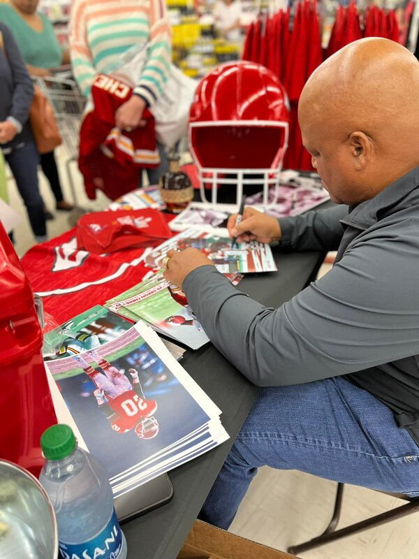 Deron signing copies at a charity event