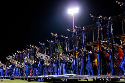 2024 Mandarins Drum Corps performance action shot of brass members playing on props.