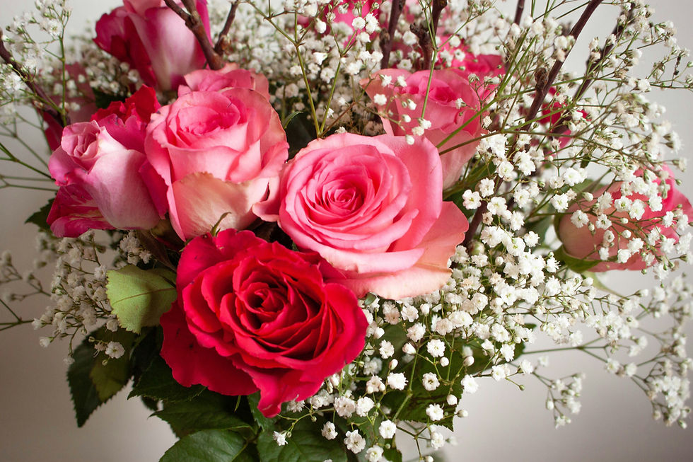 Red and pink roses, babies, breath, and mixed greenery in a lovely bouquet