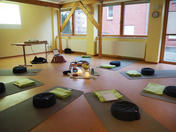 Workshopraum mit im Kreis liegenden Yogamatten