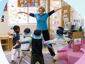 Educator role modeling movement and body awareness to a group of children. 