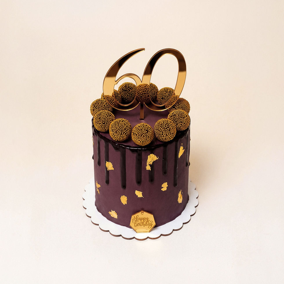 Vista tres cuartos del Éclat d’Or Fake Cake, pastel decorativo de cumpleaños en chocolate oscuro y dorado, rodeado de truf