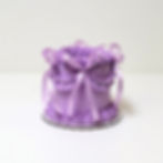 Este mini fake cake en tono lavanda suave está decorado con generosos bordones de buttercream y lazos satinados