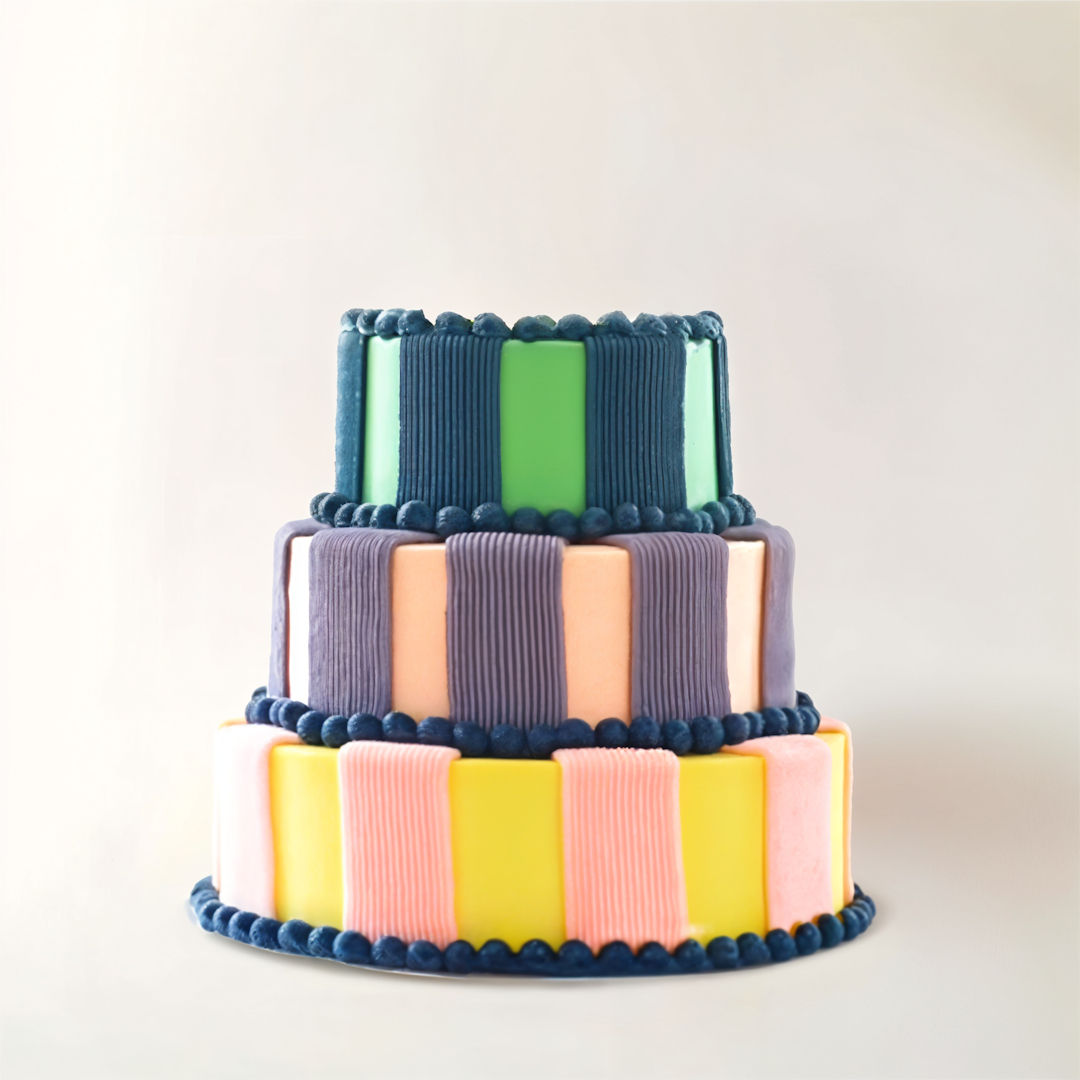 Encantador pastel falso de 3 pisos, de colores vibrantes, perfecto para fiestas infantiles.