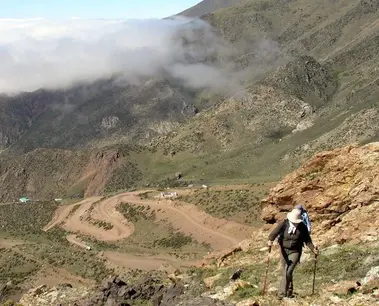 Senderista en montaña, camino sinuoso